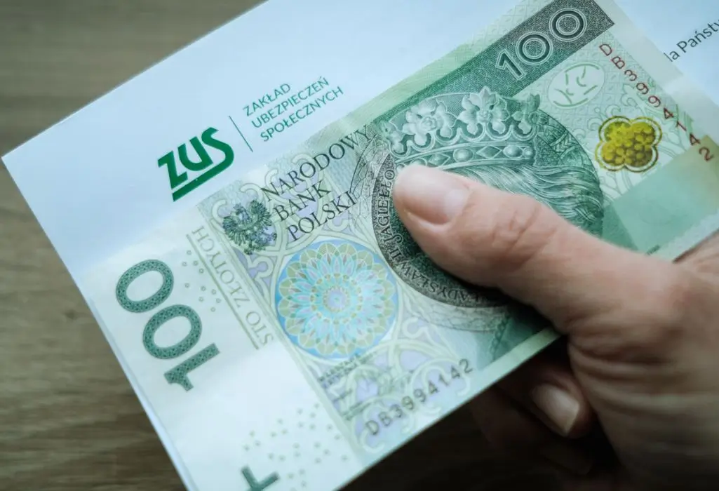Czy wiesz, jakie są najczęściej przyznawane renty w Polsce? Sprawdź, czy przysługuje Ci jedno z tych świadczeń 1 Zbliżenie na dłoń trzymającą kopertę z logo ZUS i widocznym banknotem 100 zł. Obraz symbolizuje wypłatę świadczenia, takiego jak najczęściej przyznawane renty. Zdjęcie oddaje poczucie ulgi i realnej wartości wsparcia finansowego w codziennym życiu.